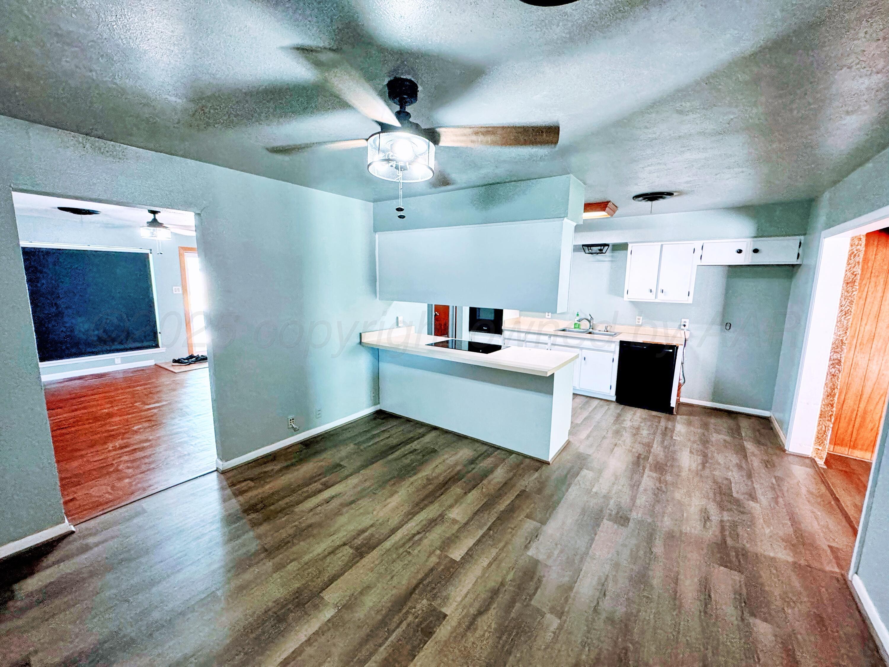 2214 Harvard Drive Perryton, TX 79070 - Photo 4 of 20 a room with stainless steel appliances kitchen island a wooden floor and ceiling fan