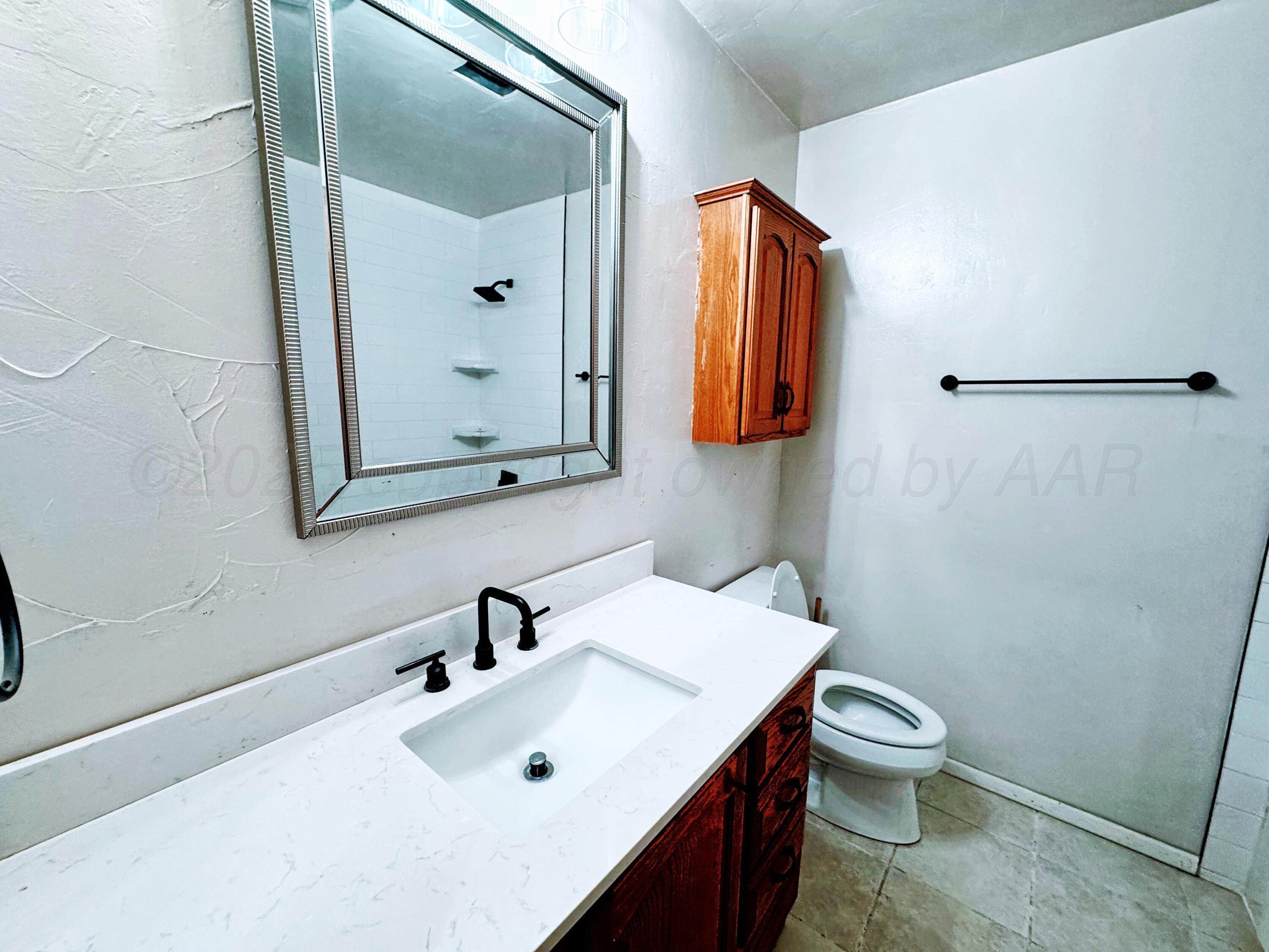 2214 Harvard Drive Perryton, TX 79070 - Photo 8 of 20 a bathroom with a sink mirror and toilet