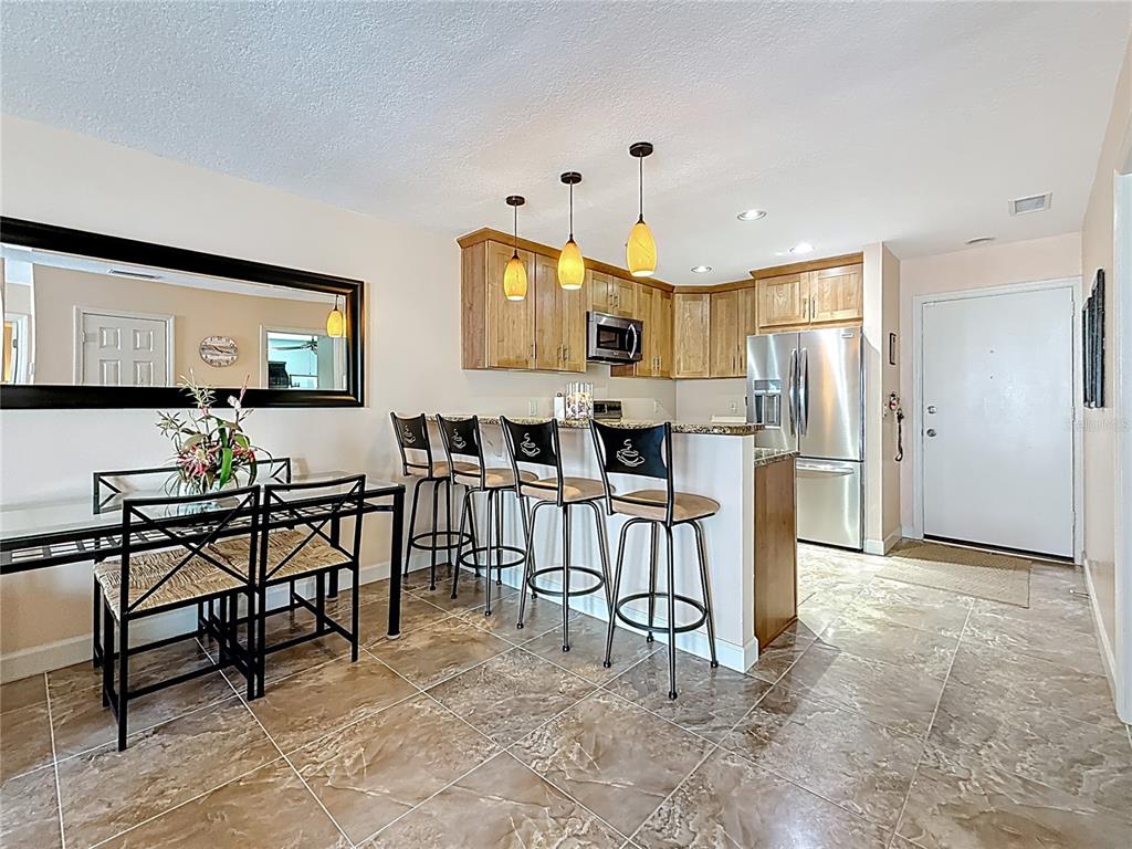 230 Medallion Boulevard, Unit G Madeira Beach, FL 33708 - Photo 11 of 38 a view of kitchen with furniture and refrigerator