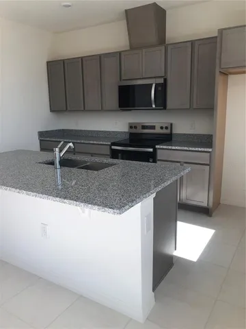 a kitchen with stainless steel appliances granite countertop a sink stove and microwave