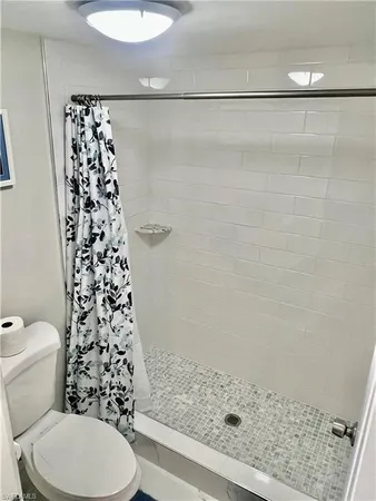 a bathroom with a toilet and a shower