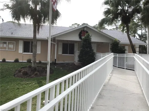 a view of a house with backyard and trees