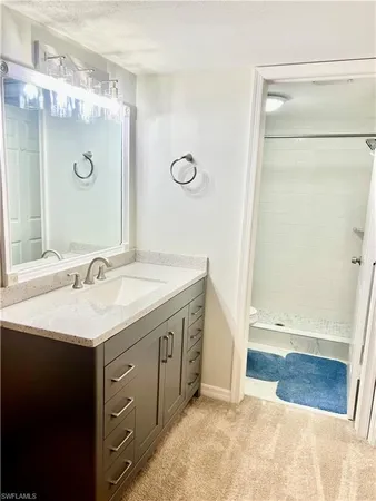 a bathroom with a granite countertop sink a mirror and a shower
