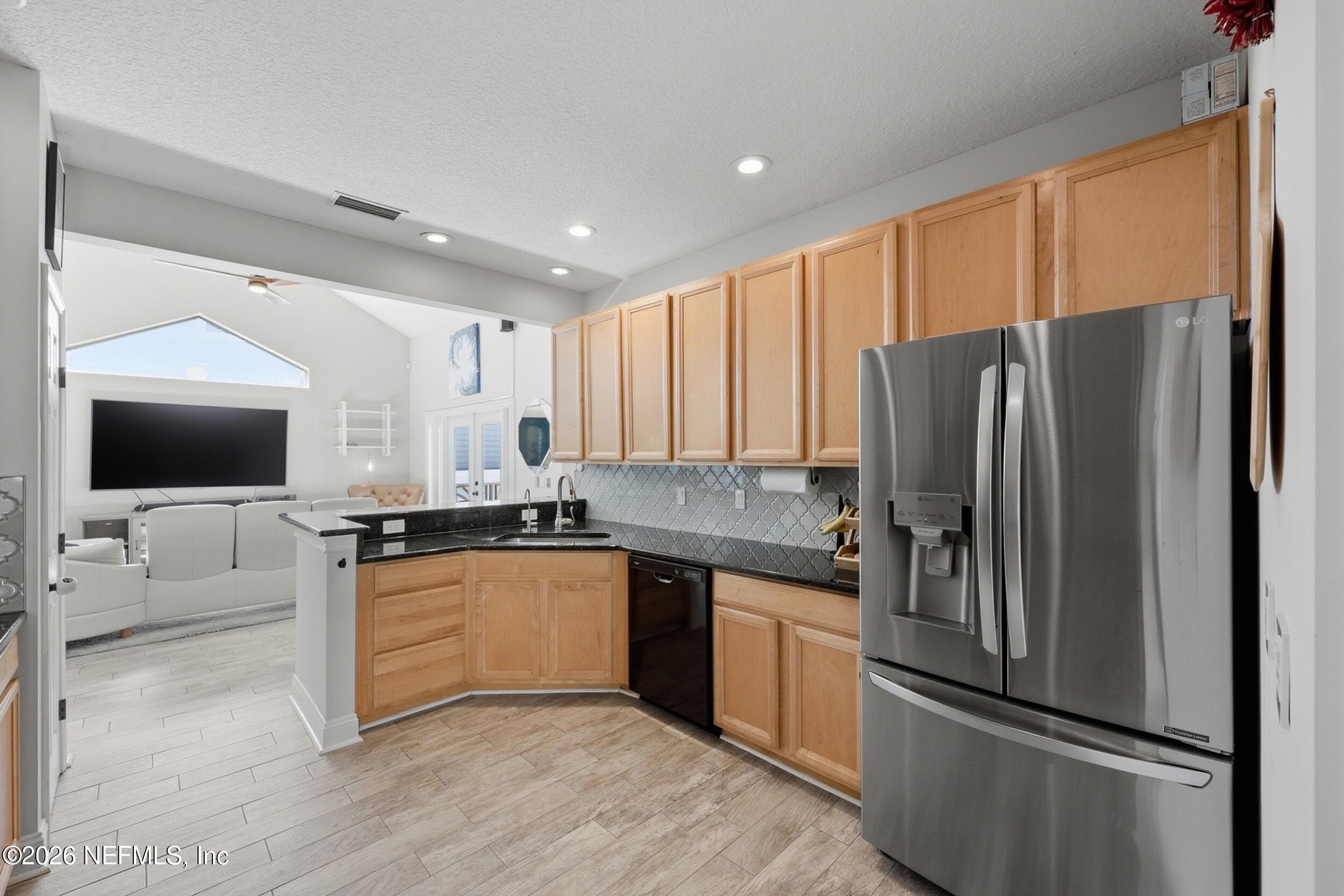 1472 Laurel Way Atlantic Beach, FL 32233 - Photo 13 of 42 a kitchen with stainless steel appliances granite countertop a refrigerator a stove a sink and a microwave