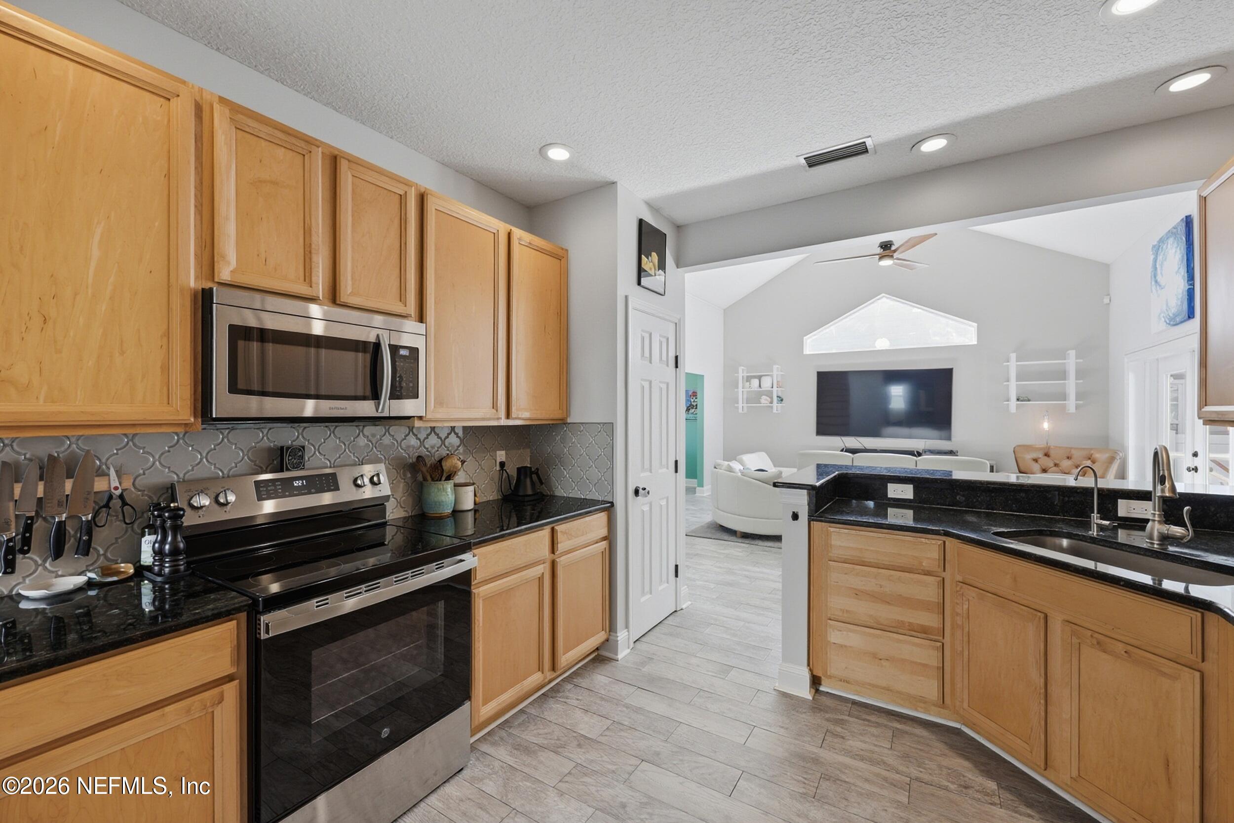 1472 Laurel Way Atlantic Beach, FL 32233 - Photo 14 of 42 a kitchen with stainless steel appliances a stove sink microwave and cabinets