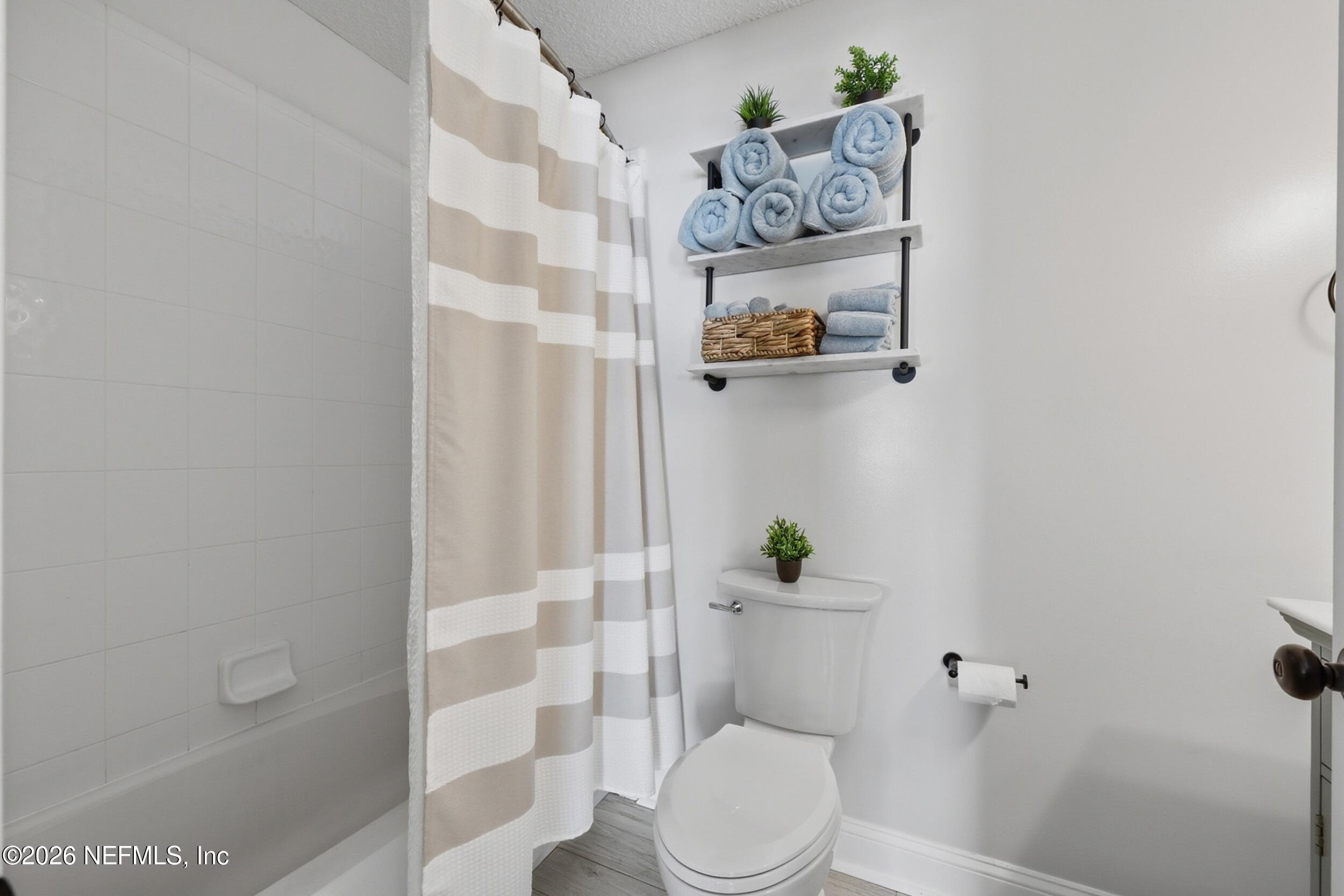 1472 Laurel Way Atlantic Beach, FL 32233 - Photo 28 of 42 a white toilet sitting next to a shower curtain