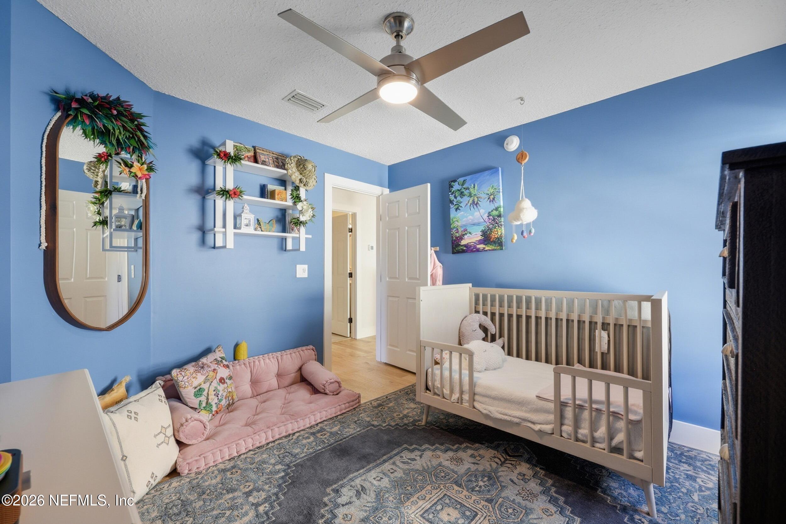 1472 Laurel Way Atlantic Beach, FL 32233 - Photo 30 of 42 a bedroom with a white bed and a chandelier
