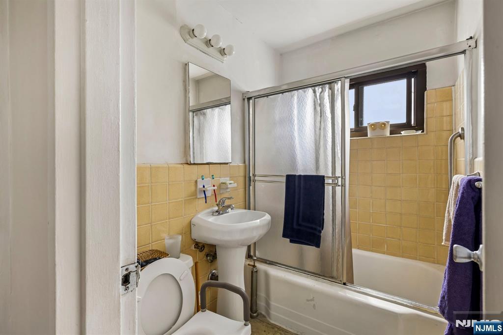 3060 Edwin Avenue, Unit 3D Fort Lee, NJ 07024 - Photo 10 of 16 a bathroom with a sink toilet and shower