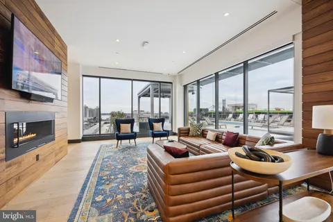 a living room with furniture a fireplace and large windows