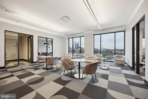 a living room with furniture and floor to ceiling windows