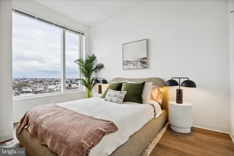 a bedroom with a large bed and a potted plant