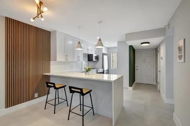 a kitchen with stainless steel appliances a table and chairs in it