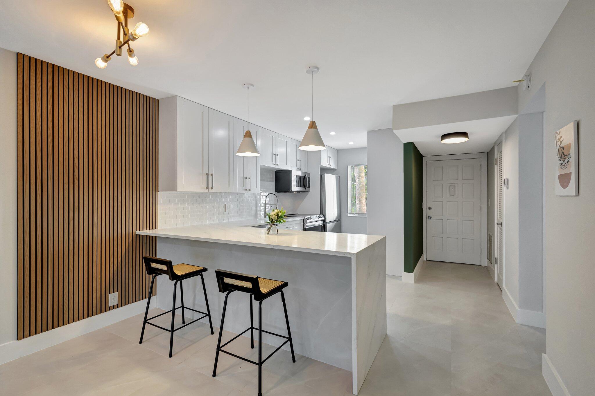 a kitchen with stainless steel appliances a table and chairs in it