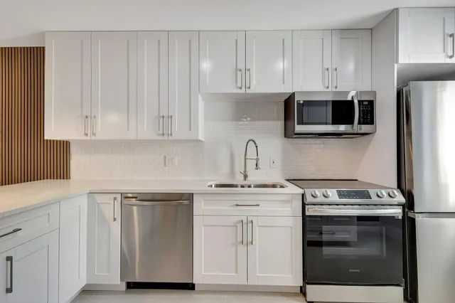 a kitchen with white cabinets and stainless steel appliances