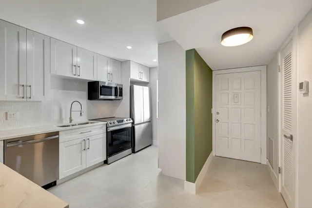 a kitchen with stainless steel appliances granite countertop a refrigerator and a sink