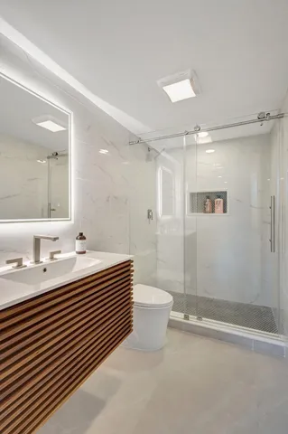 a bathroom with a double vanity sink toilet and shower