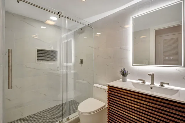 a bathroom with a sink a toilet and shower