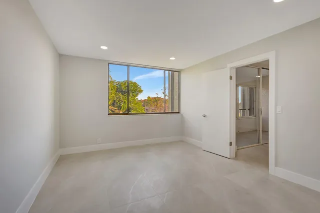 an empty room with windows and closet