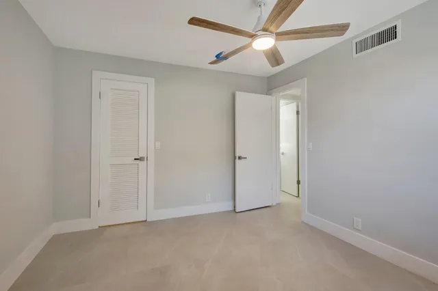 an empty room with chandelier fan