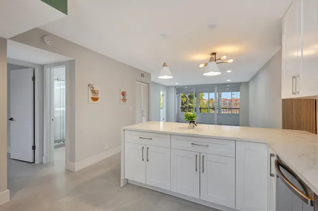 a view with a sink and mirror with cabinets