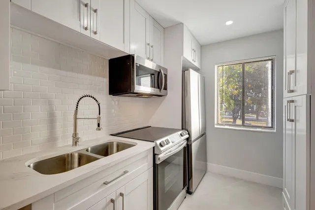 a kitchen with stainless steel appliances granite countertop a sink and a stove