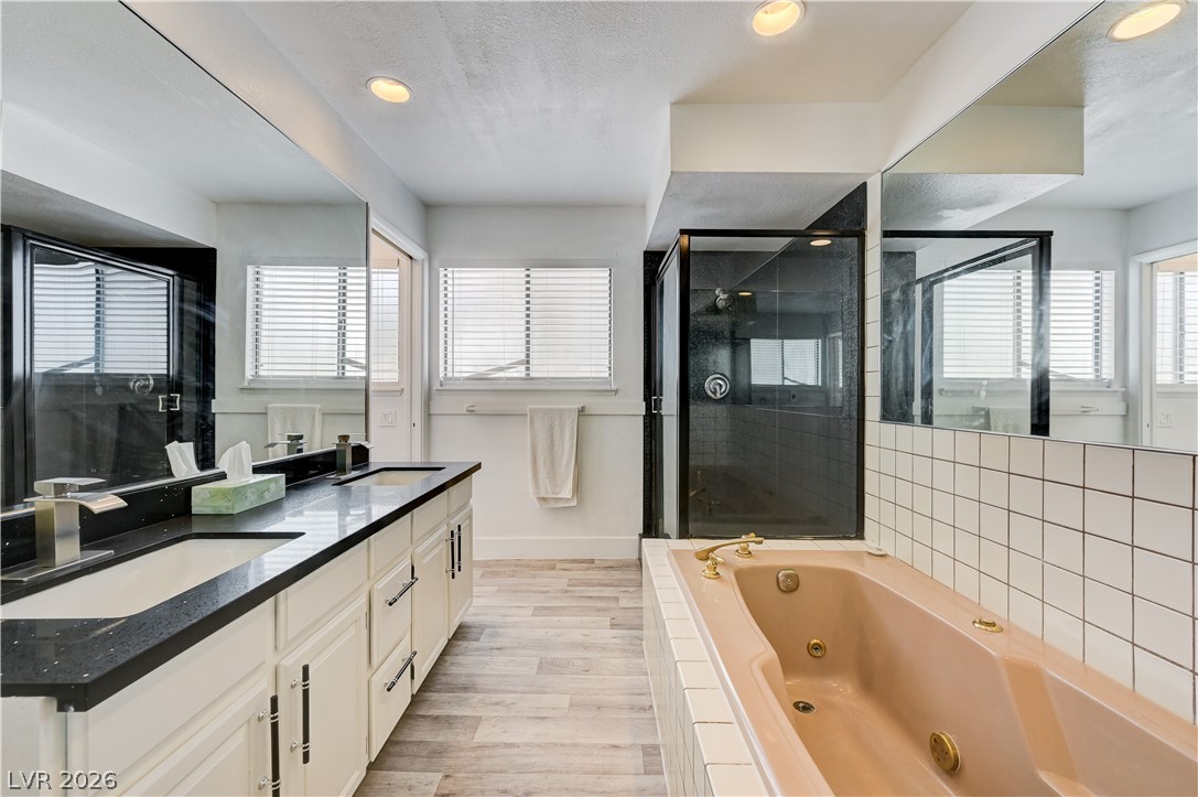 1751 East Reno Avenue, Unit 228 Las Vegas, NV 89119 - Photo 23 of 39 Dual vanities and a relaxing soaking tub create a luxurious primary bathroom retreat.