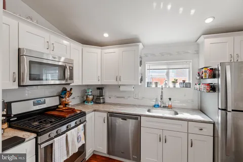 a kitchen with granite countertop a sink stove and cabinets