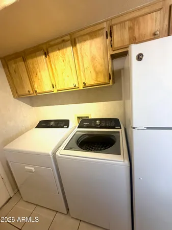 a room with stainless steel appliances a refrigerator a sink a washer and dryer