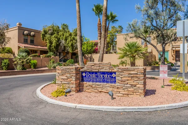 front view of a house with a fountain and potted plants