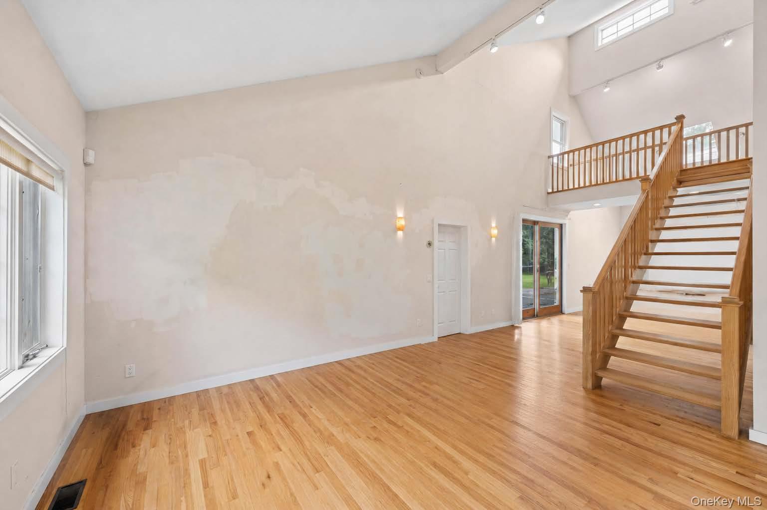131 Red Creek Road Hampton Bays, NY 11946 - Photo 34 of 35 a view of a hallway with wooden floor and stairs
