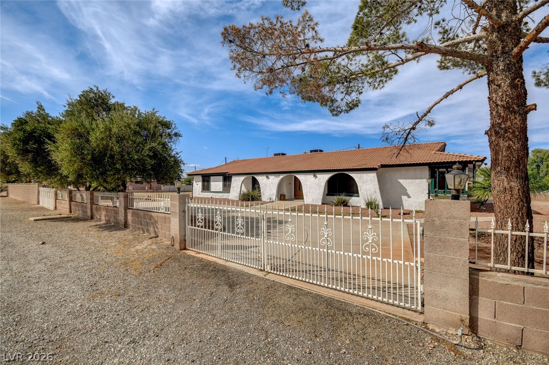 1401 Sharon Road Las Vegas, NV 89106 - Photo 7 of 73 A secure gated entrance leads to this classic southwestern home under clear desert skies.
