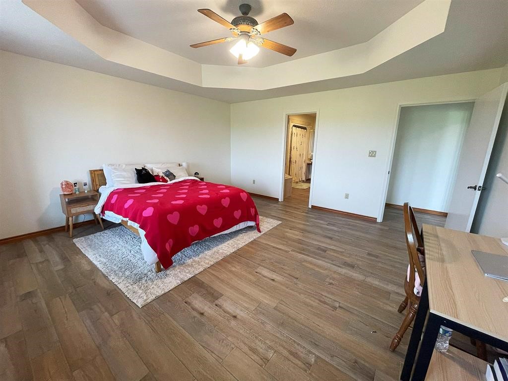 13979 Shellhammer Road Winnie, TX 77665 - Photo 22 of 47 a bedroom with a bed and wooden floor