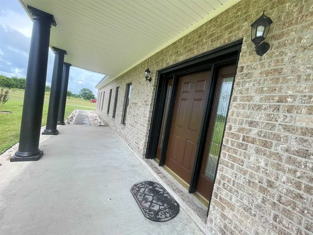 an aerial view of a house with swimming pool and green yard