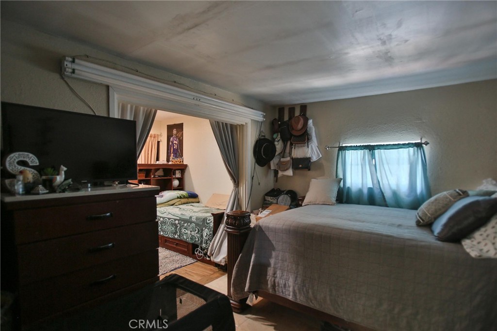 2525 West 10th Street Santa Ana, CA 92703 - Photo 27 of 37 a bedroom with a bed and a flat tv screen on the dresser