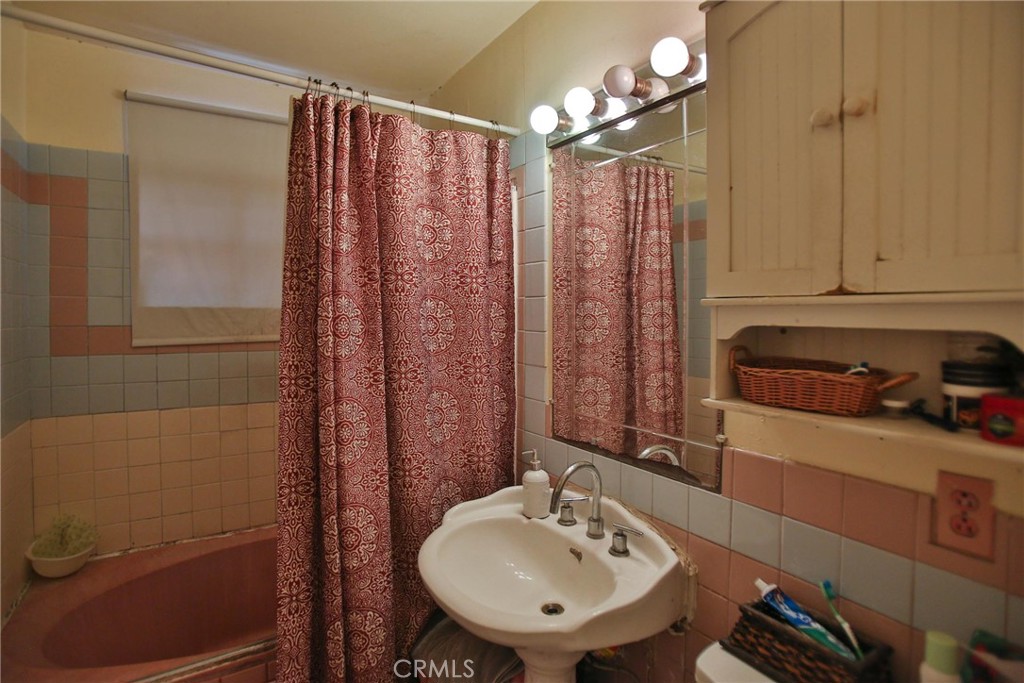 2525 West 10th Street Santa Ana, CA 92703 - Photo 30 of 37 a bathroom with a sink a toilet and shower curtain