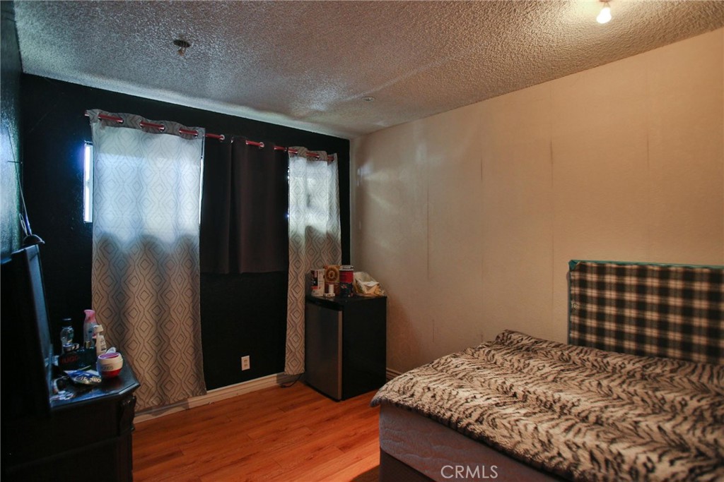 2525 West 10th Street Santa Ana, CA 92703 - Photo 35 of 37 a bedroom with a bed and wooden floor