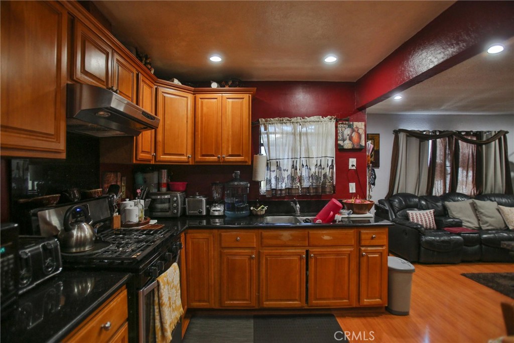 2525 West 10th Street Santa Ana, CA 92703 - Photo 8 of 37 a kitchen with stainless steel appliances granite countertop a stove a sink dishwasher and cabinets with wooden floor