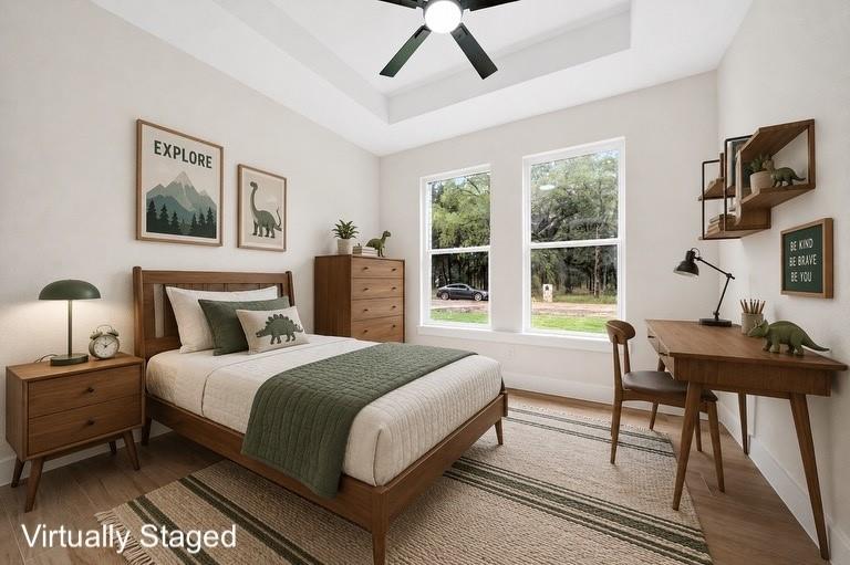120 Springwood Road Enchanted Oaks, TX 75156 - Photo 25 of 37 Tray ceiling with a ceiling fan, two large windows, wood-finish flooring, and built-in wall shelving