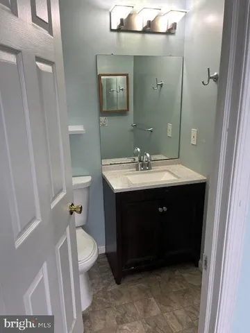 a bathroom with a sink vanity and toilet