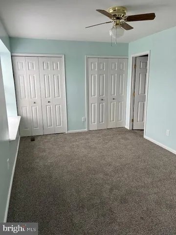 en empty room with windows and fan