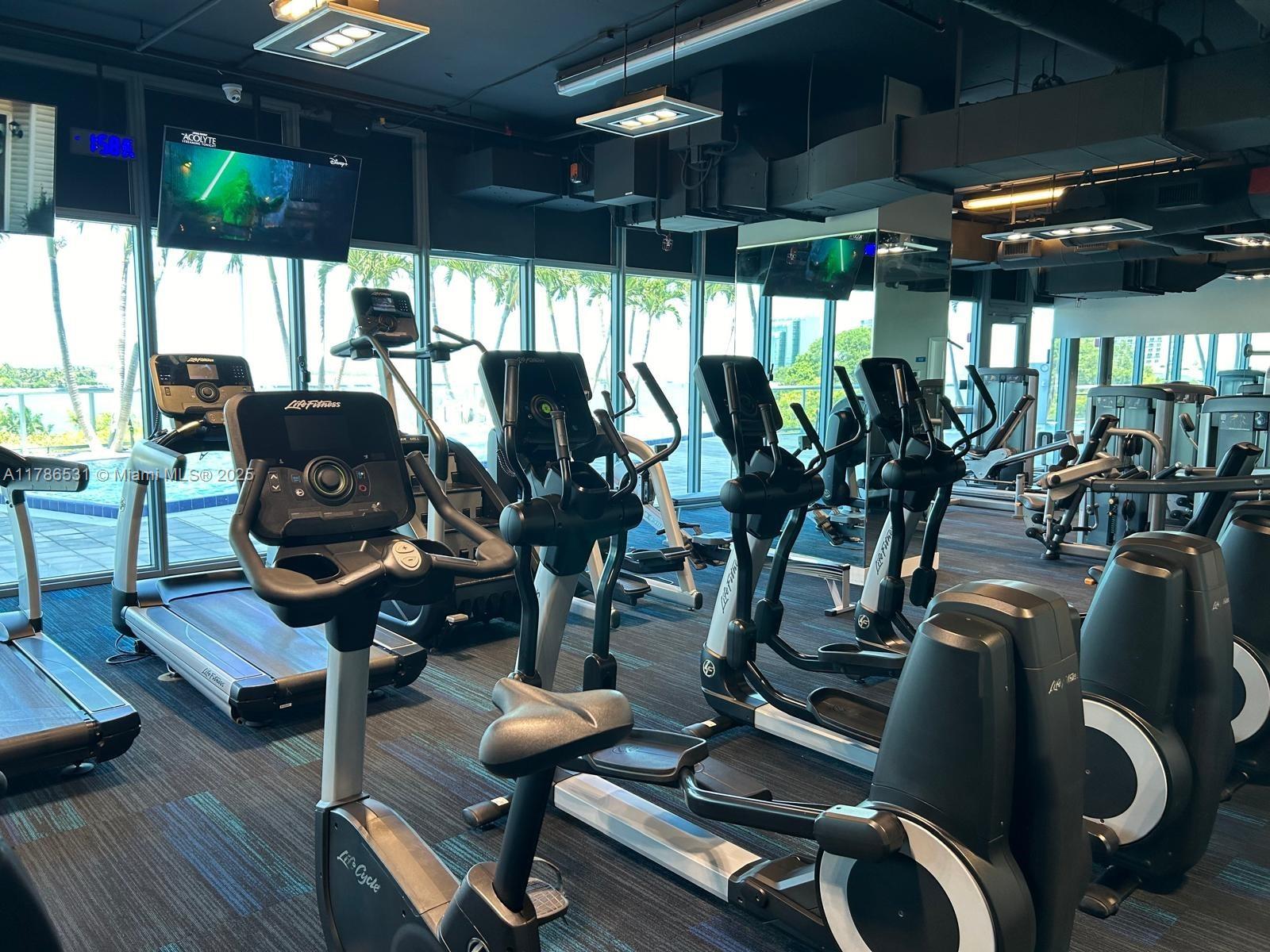 601 Northeast 36th Street, Unit 801 Miami, FL 33137 - Photo 12 of 24 a room with gym equipment and a large window