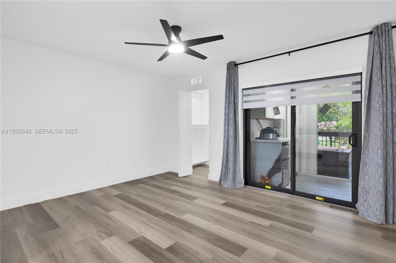 13028 Southwest 88th Lane, Unit A205 Miami, FL 33186 - Photo 13 of 37 a view of empty room with wooden floor and fan