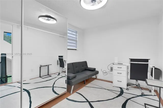 a living room with furniture a flat screen tv and a window