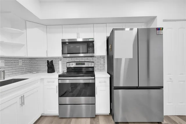 a kitchen with a refrigerator sink and microwave