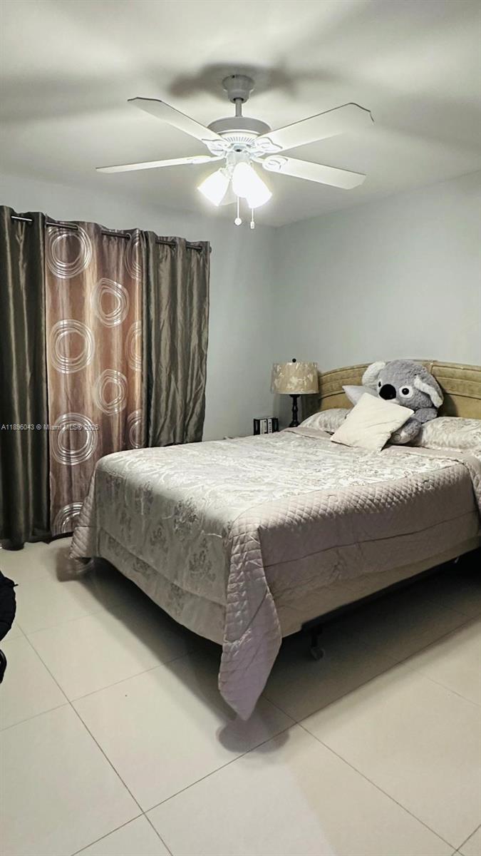 18880 Northwest 57th Avenue, Unit 208 Hialeah, FL 33015 - Photo 13 of 28 a bedroom with a bed and a chandelier