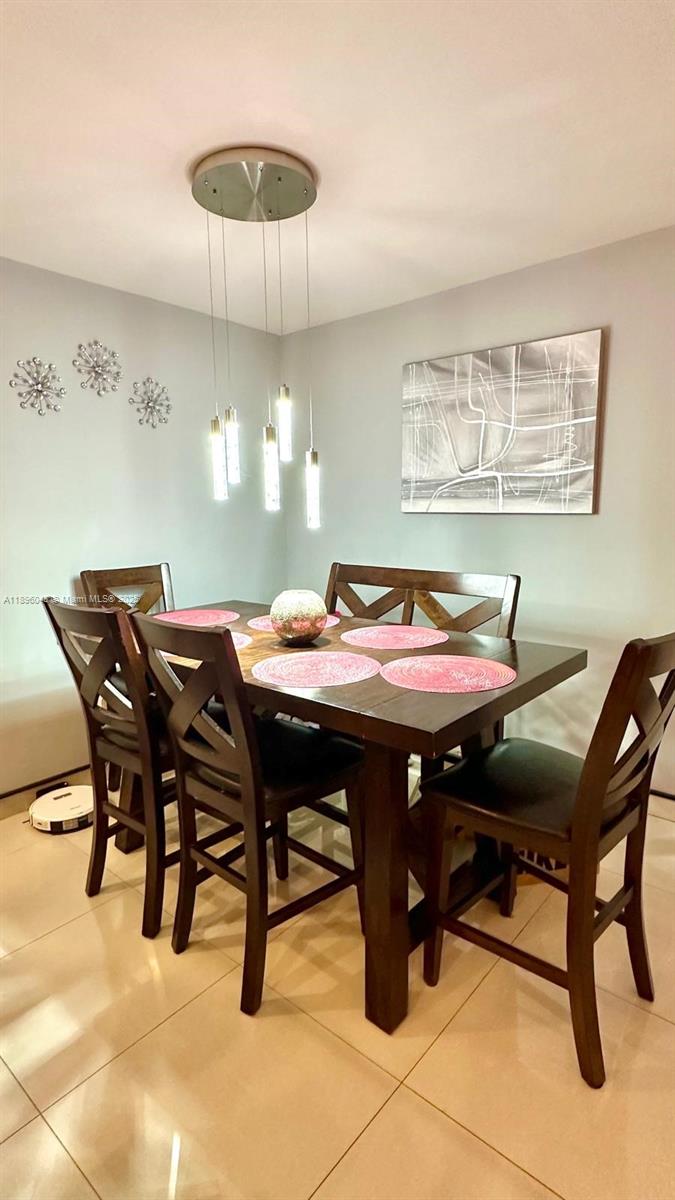 18880 Northwest 57th Avenue, Unit 208 Hialeah, FL 33015 - Photo 2 of 28 a view of a dining room with a table and chairs