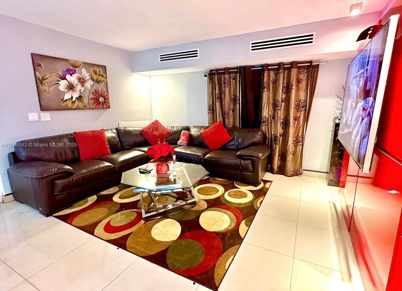 18880 Northwest 57th Avenue, Unit 208 Hialeah, FL 33015 - Photo 5 of 28 a living room with furniture and a rug