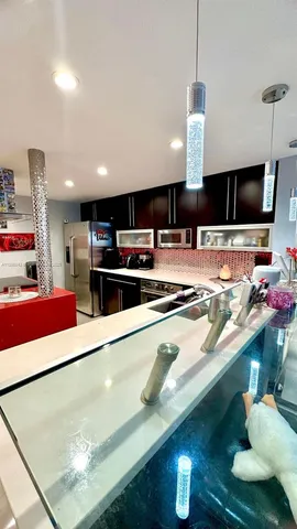 a kitchen with stainless steel appliances a stove a refrigerator and a sink