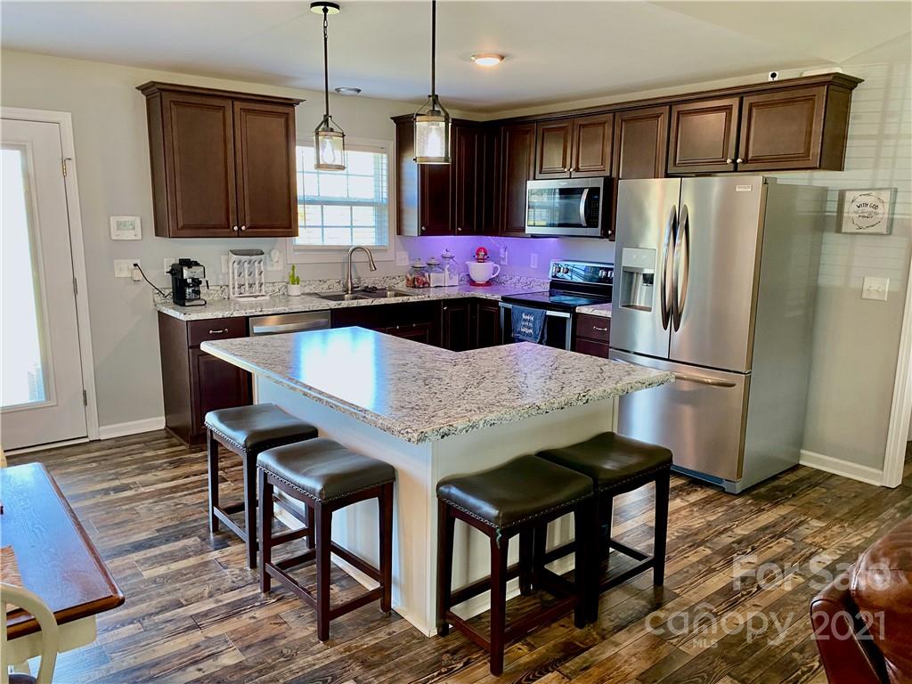 6316 Bill Sain Road Vale, NC 28168 - Photo 11 of 15 a kitchen with granite countertop a refrigerator a stove a sink and a microwave
