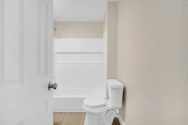 a white toilet sitting next to a shower
